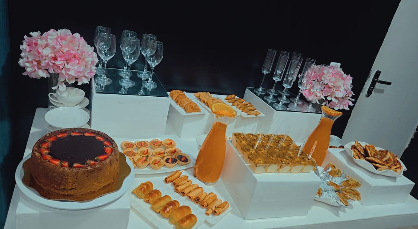 Mesa de coffee break com doces, salgados e sumos